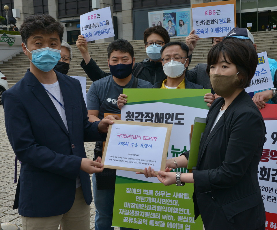 KBS 직원에게 인권위 권고문 전달하는 김주현 장애의 벽을 허무는 사람들 대표